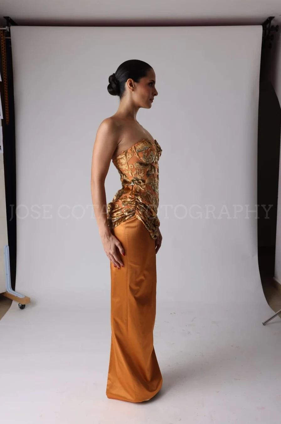Vestido largo de corset dorado y falda de satín cobre, vista de perfil