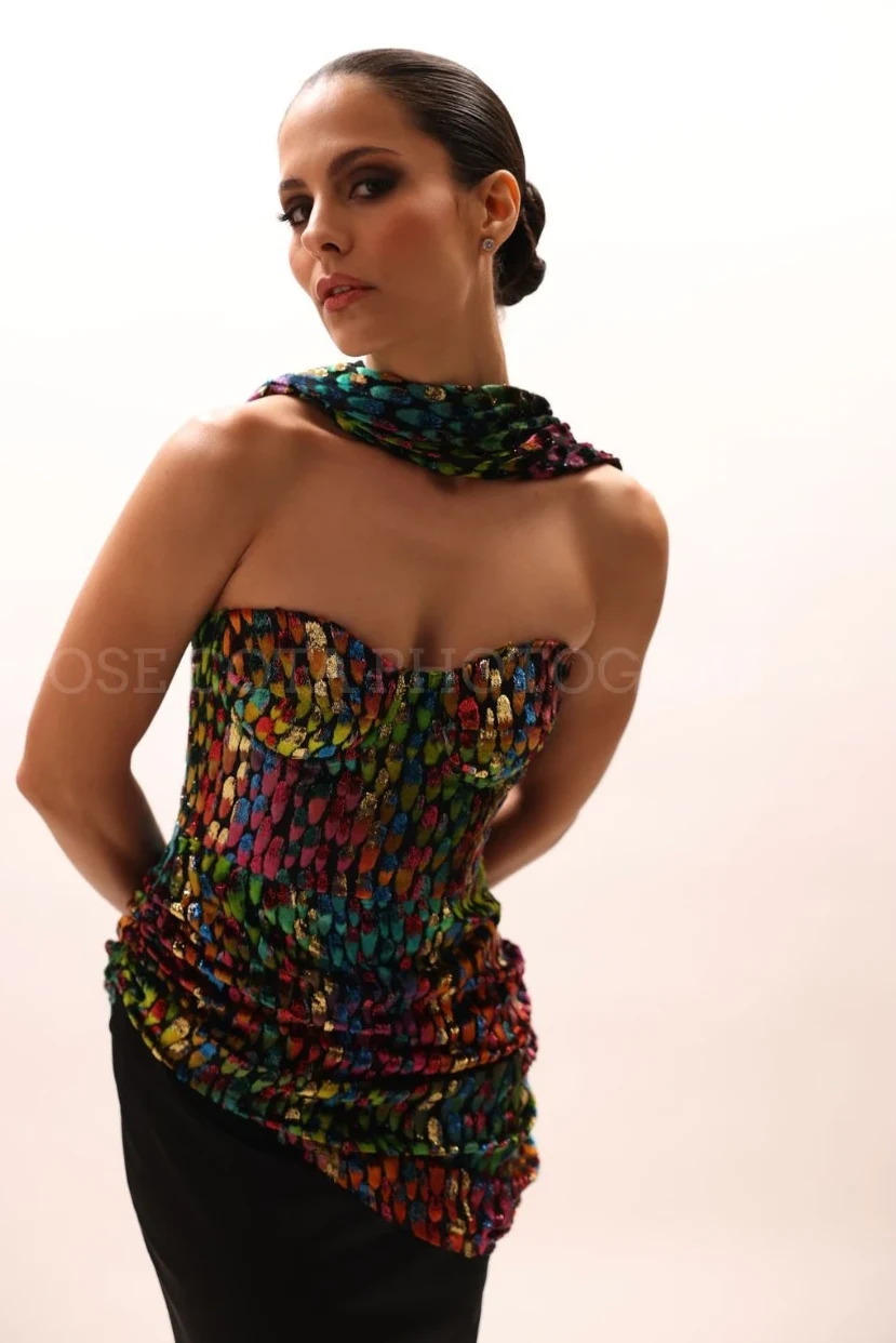 Corset iridiscente con mascada al cuello sobre fondo claro